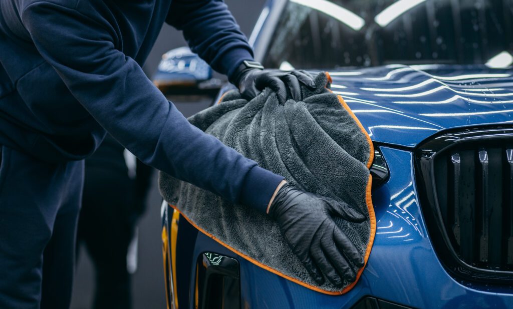 Using a microfiber towel to dry a car.