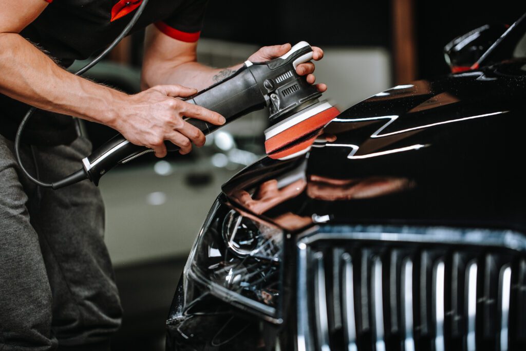 A detailer uses a polisher to restore a vehicle's paint.