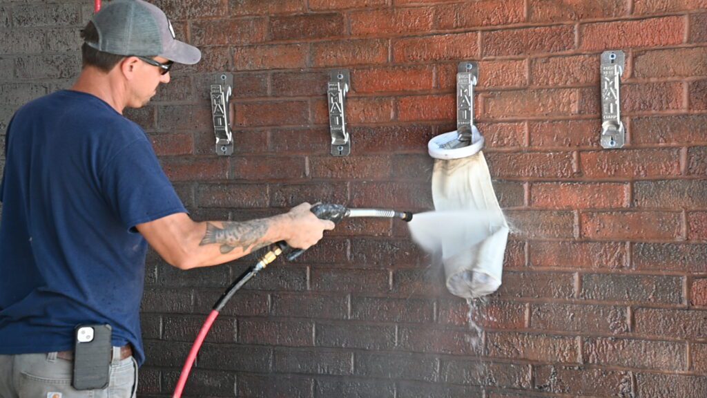 Spraying a vacuum filter bag.