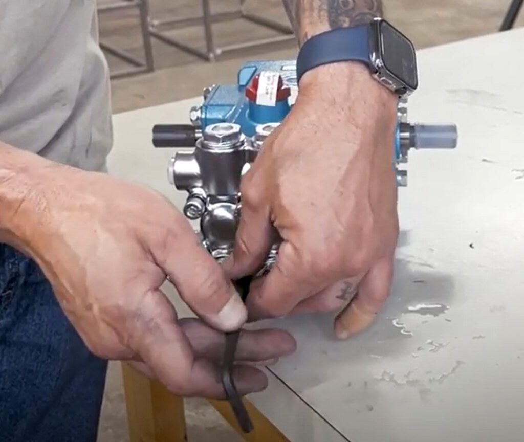Removing bolts holding on the CAT 5CP pump's head.