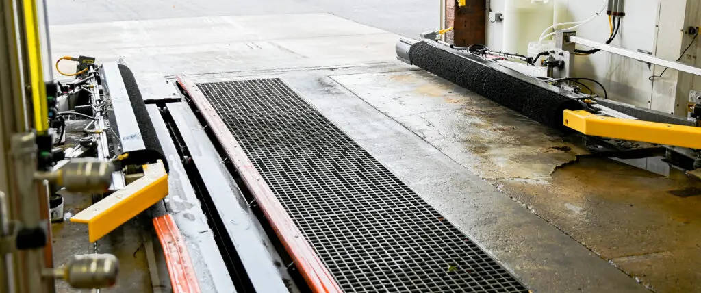 Tire dressing applicator brushes inside a car wash tunnel.